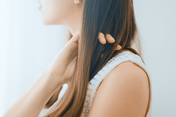ストレートヘアに触れる女性
